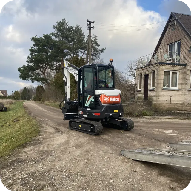Bobcat E35z mini ekskavatorius atvyksta prie gyvenamojo namo